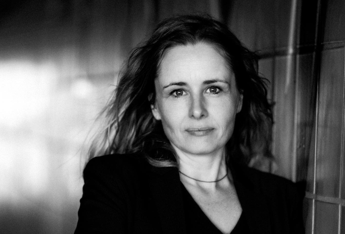 Monica Hellström looking directly at camera. Black and white portrait.