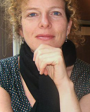 Deirdre Fishel looks at the camera smiling with her hand on her chin.