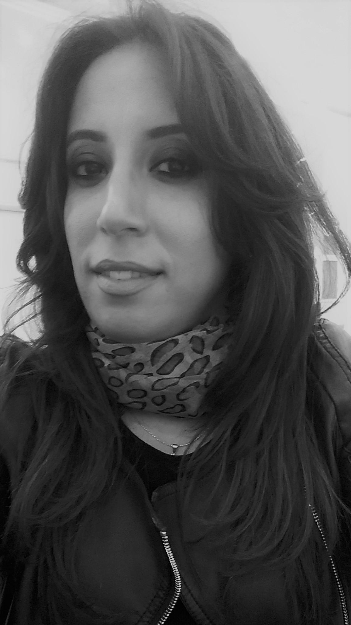 Hiba Dhaouadi looks directly at the camera and smiles. the photo is in black and white.