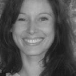 Kate McLarnon looks at camera and smiles. Photo in black and white.