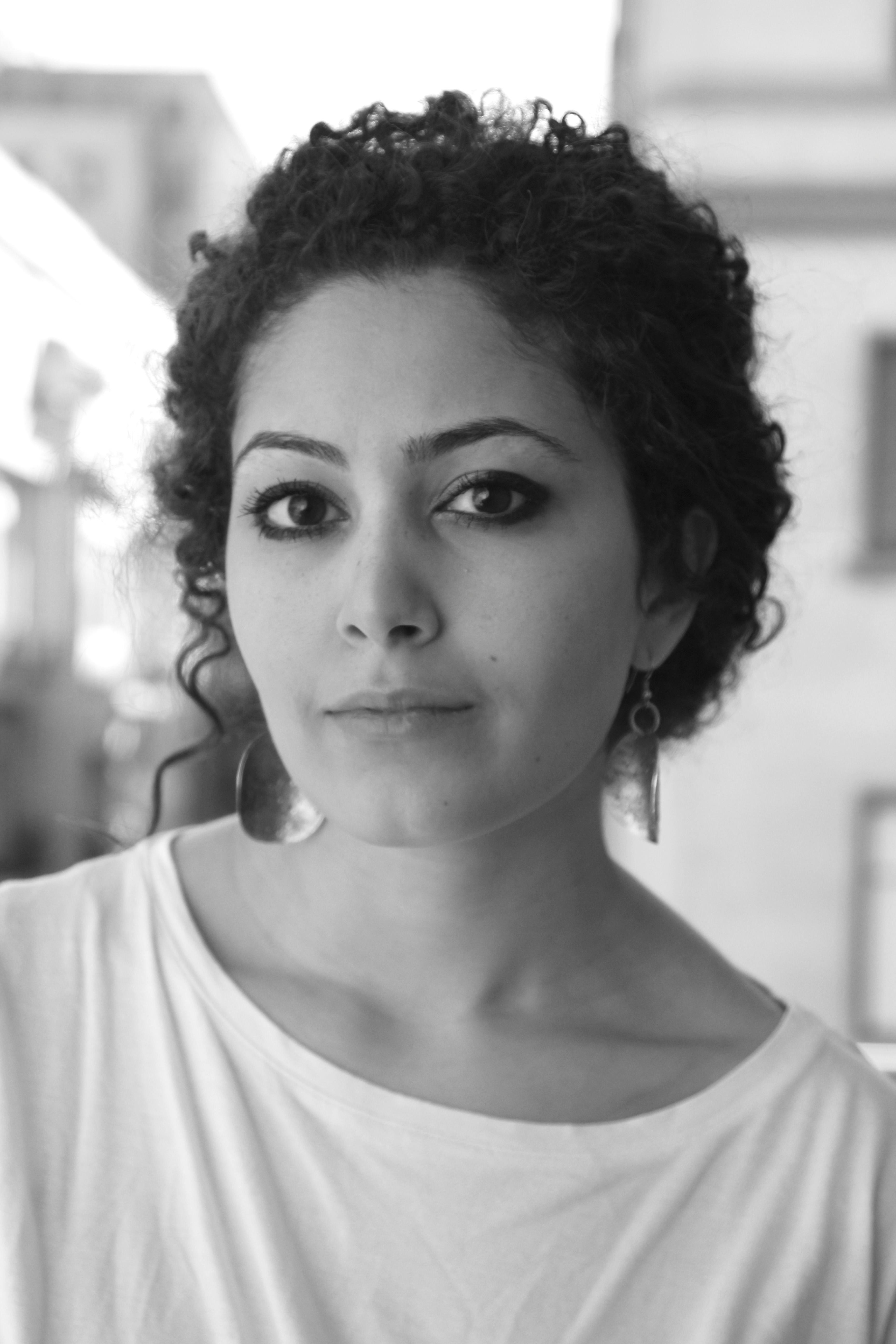 Hanan Abdalla looks directly at the camera. The photo is in black and white.