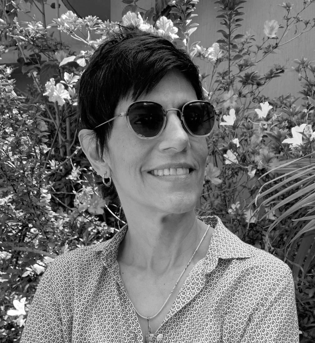 Meena Nanji looks off to the right of the camera. Portrait in black and white.