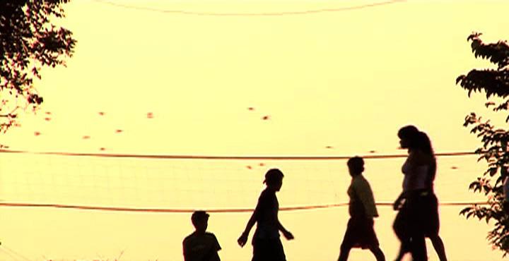 The silhouettes of four people against a yellow sky.