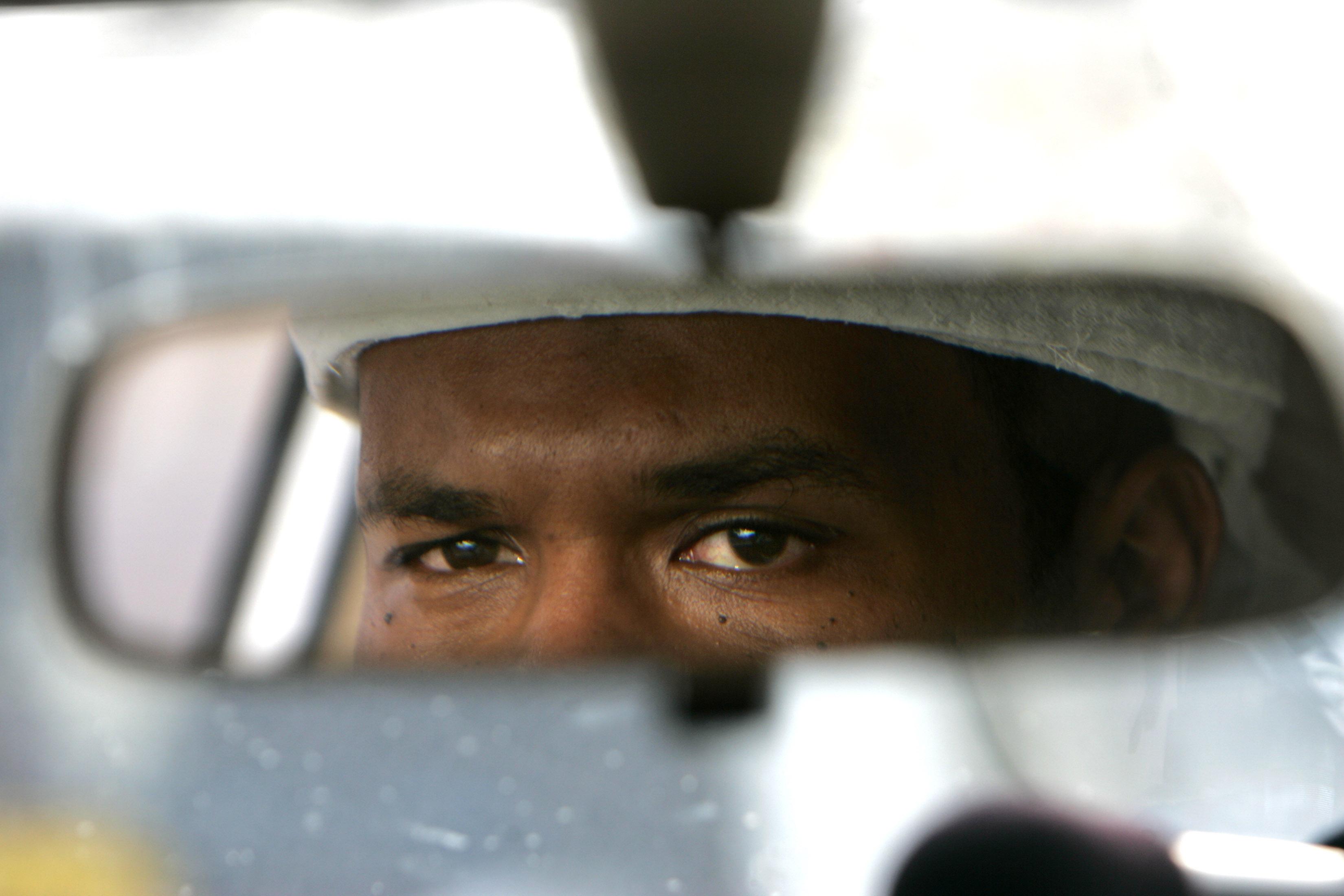 A closeup of a rearview mirror with a man's eyes reflected in it.